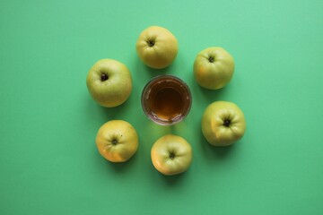 Apples and apple juice in a glass on a green background. The view from above