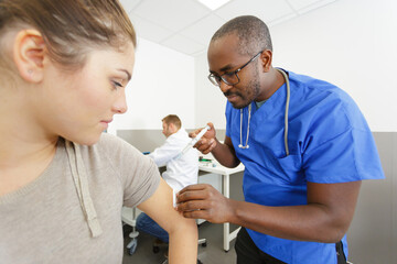 male doctor vaccinating a female patient