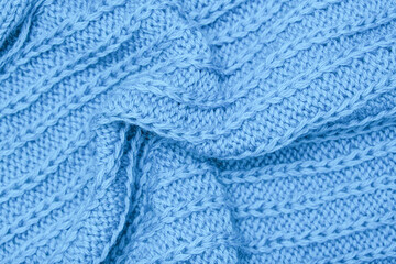 Crumpled knitted blue fabric background, waved and twisted, curved turquoise woolen knitwear