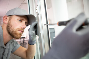 handyman fitting a new door using a screwdriver at home