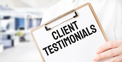 Text Client Testimonials on white paper plate in businessman hands in office. Business concept