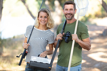 Fototapeta premium couple going fishing with fish rod and net