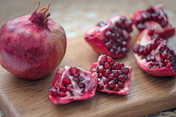 Ripe pomegranate fruit on wooden board background