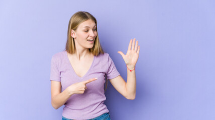 Fototapeta na wymiar Young blonde woman isolated on purple background smiling cheerful showing number five with fingers.