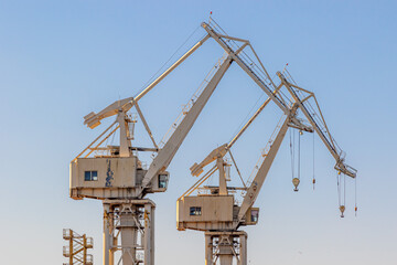 Yellow harbor cranes against the blue sky. Port cranes
