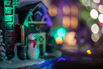 Pequeña casa con muñeco de nieve para decoración navideña de jengibre iluminada con bokeh de...