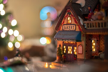 Pequeña casa para decoración navideña de jengibre iluminada con bokeh de fondo