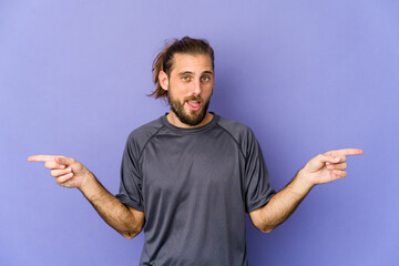 Young man with long hair look pointing to different copy spaces, choosing one of them, showing with finger.