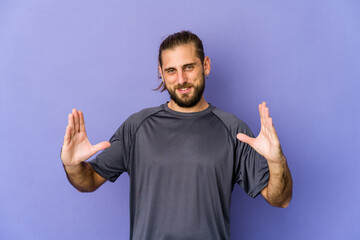 Fototapeta premium Young man with long hair look receiving a pleasant surprise, excited and raising hands.