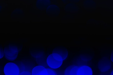 Abstract pattern of blue bokeh lights on black background