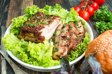 Baked pork belly with spices. Sliced breast served with herbs. Traditional dish of Ukraine. Close-up.