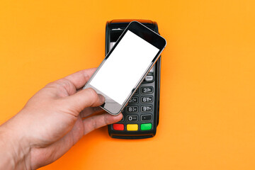Payment for purchases with a mobile phone. White screen of a smartphone and a payment terminal. Place for your text. Business and technology