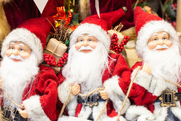 Three Santa Claus with gifts. Santa Claus dolls. Christmas decoration. Santa Claus toy. Happy new year concept. Winter holidays festive decoration. Christmas magic. Several Santa doll. 