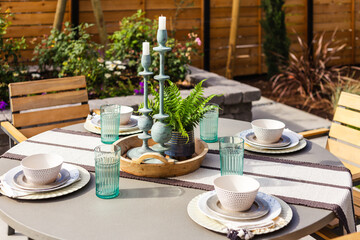 Outdoor patio detail: table set for breakfast, lunch, or dinner outside new home