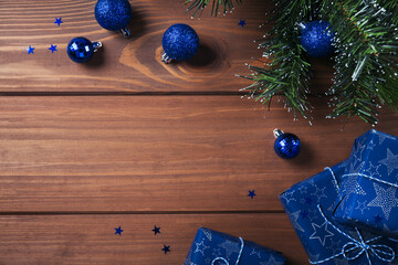 Fototapeta na wymiar Christmas composition. Gifts, fir tree branches, blue decorations on wooden background. Christmas, winter, new year holiday concept. Flat lay, top view