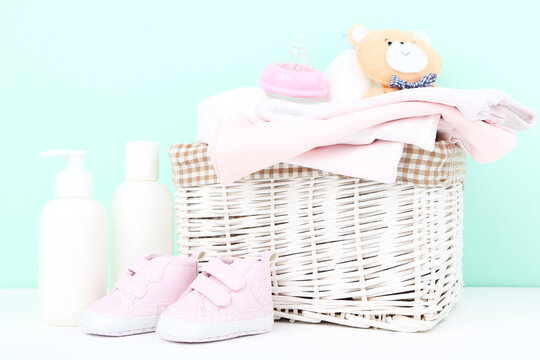 Baby clothes with bottles and soft bear toy on blue background