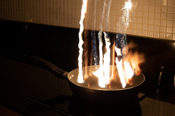Freeze light fire on a pan in a kitchen - 396643787