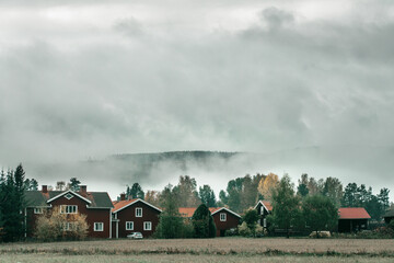 Fototapeta na wymiar Houses in foggy landscape
