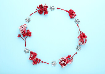 Christmas composition. Red berries with snowflakes on blue background