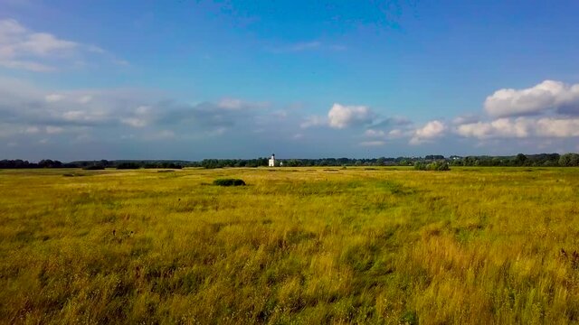 White Church on the hill. Summertime, daylight, green field, gree bushes. Church of interception of the holly virgin on the Nerl river. Russian Federation, Vladimir region, Bogolubovo.