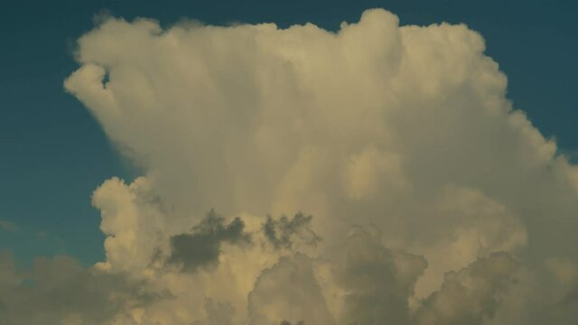 Thick white clouds float across the blue summer sky. Timelapse. Sunny.