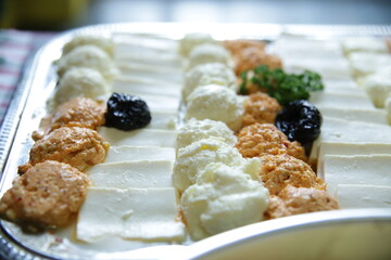 Different types of cheese and cream arranged on a half-table platter from catering for different types of celebration.Close up,blurred background.