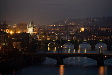 Fototapeta premium night view of the Vltava river and the bridges on it between the bridges and the Charles Bridge and the surrounding architecture and light from the street lights in the center of Prague after sunset