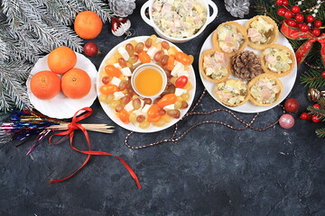 Christmas new year dishes, traditional festive salad olivier and cheese with tomatoes, grapes and honey with fir branches and cones and decorations, dish design idea, selective focus,