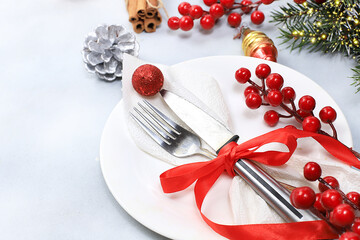 Christmas new year table with plate, fir branches, decorations and cones, festive atmosphere, preparation for dinner, selective focus