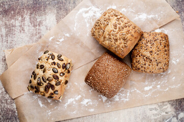 Gold rustic crusty loaves of bread and buns on wooden background. Still life captured from above top view, flat lay.