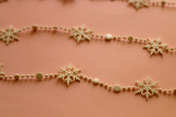 Snowflake garland on pink background. Selective focus.