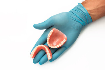 False teeth prosthesis. Doctor Dentist. A dental technician holds a false jaw in his hand. Dental prosthesis in the hands of the doctor close-up. Dentistry conceptual photo. Prosthetic dentistry