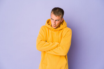 Young caucasian handsome man frowning face in displeasure, keeps arms folded.