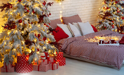 Interior Christmas bedroom night. Cozy Decorated white bedroom for  holidays with Christmas tree and gifts. Glowing Xmas tree in dark at night. Checkered bedding on the bed. Scandinavian room style