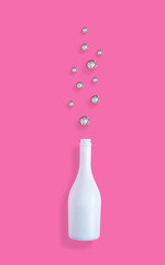 Creative Christmas and New year concept with champaign bottle and shiny disco balls on pastel pink background. Flat lay design