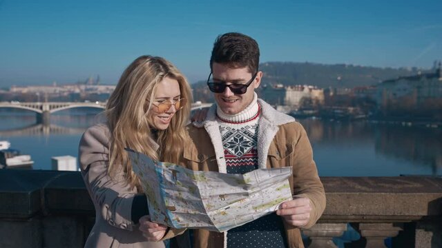 Young tourists examining the map of Prague. Tourism, travel, friendship, love, concept. Filmed on REd 4k, 10 bit color