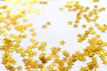Festive background. Shining confetti stars on white background. Christmas. Wedding. Birthday. Happy woman's day. Mothers Day. Valentine's Day. Flat lay, top view, copy space.
