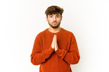 Young arab man on white background praying, showing devotion, religious person looking for divine...