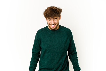 Young arab man on white background laughs and closes eyes, feels relaxed and happy.