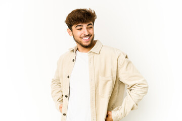 Young arab man on white background laughs happily and has fun keeping hands on stomach.