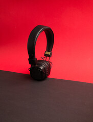 Classic black wired headphones on colored paper background. Retro style. 80s. Pop culture. Top view. Minimal Music Concept