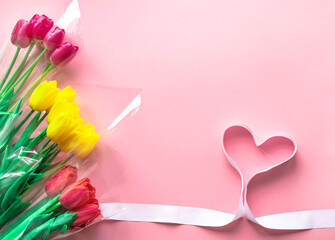 Fresh bouquets of tulips flowers on delicate pastel light pink paper background. Greeting card for Valentine's Day, Mother's or Woman's Day.