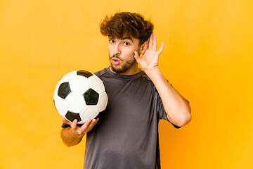 Young soccer player indian man trying to listening a gossip.