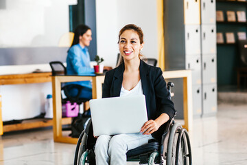 Mexican woman in wheelchair with her colleagues at workplace in Latin America