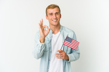 Young caucasian man holding a american flag isolated on white background