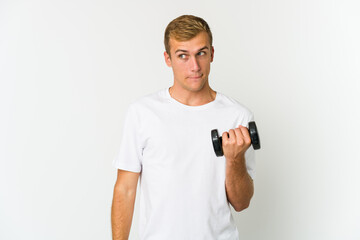 Fototapeta na wymiar Young caucasian man holding a weight isolated on white background