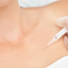 Near eye injection at spa salon. Doctor hands. Closeup. High quality. Pretty female patient. Beauty...