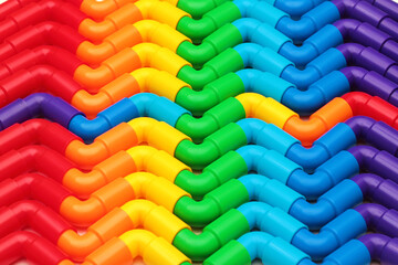 Rainbow colored plastic pipes as background