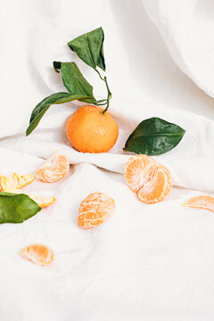 View of orange fruit and slices on tablecloth