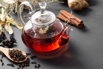 Winter herbs and spices tea in glass teapot or mug, alternative medicine for the immune system,...